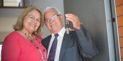 Couple de retraités tenant les clés de leur nouvelle maison à l'étranger